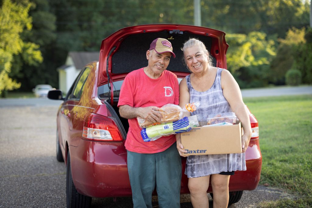 Husband and wife packing care with food after visiting food pantry