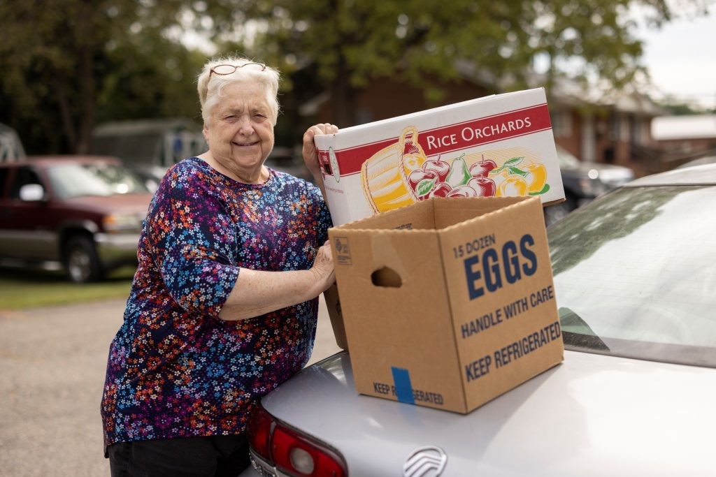 Older woman loading her car with food after visiting the Cumberland Cares food pantry