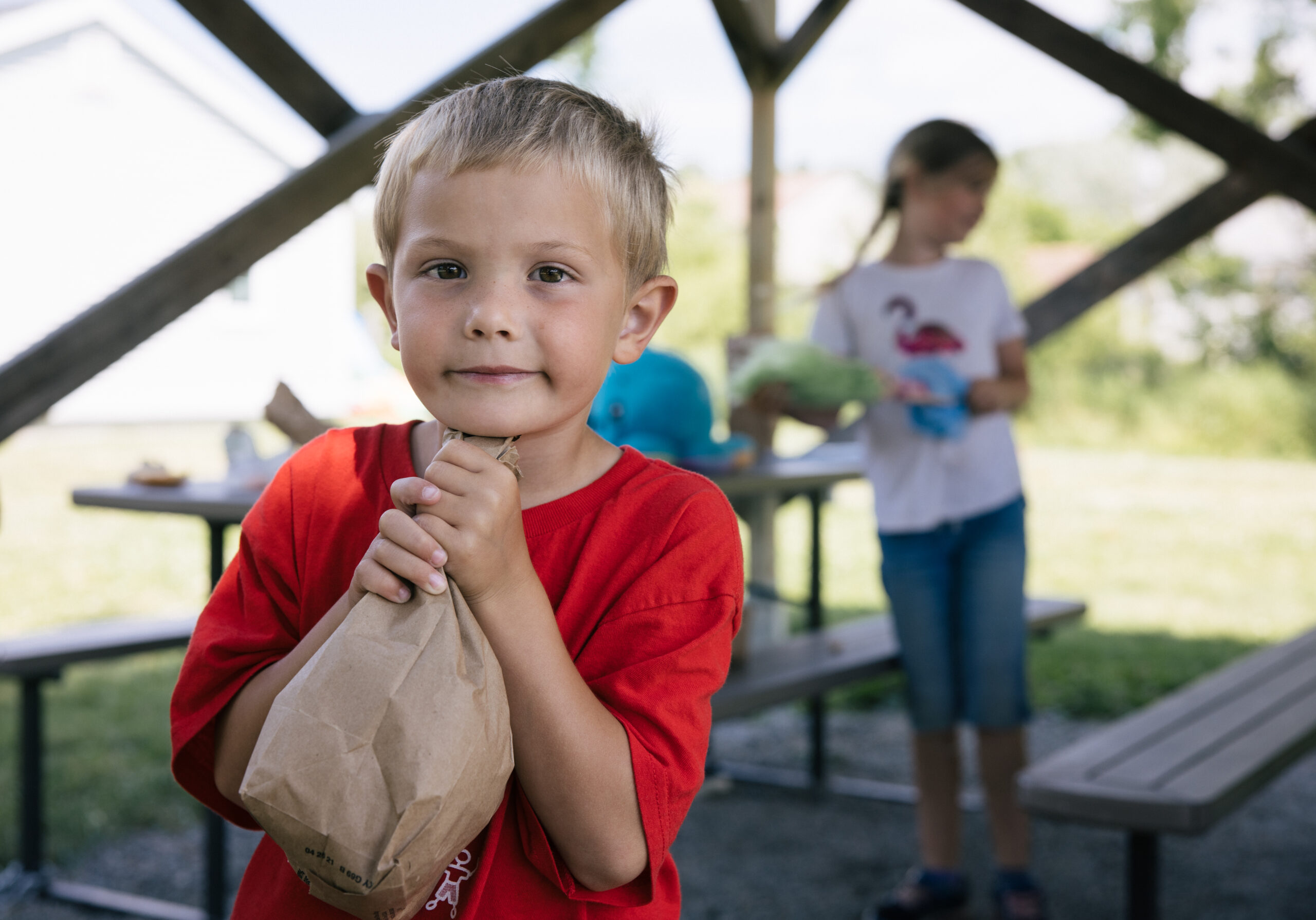 Hermes, 6, receives summer meals at a park near his home.