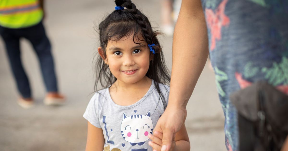 Smiling girl at a Feed More partner food pantry distribution feature on a heartfelt thank you post.