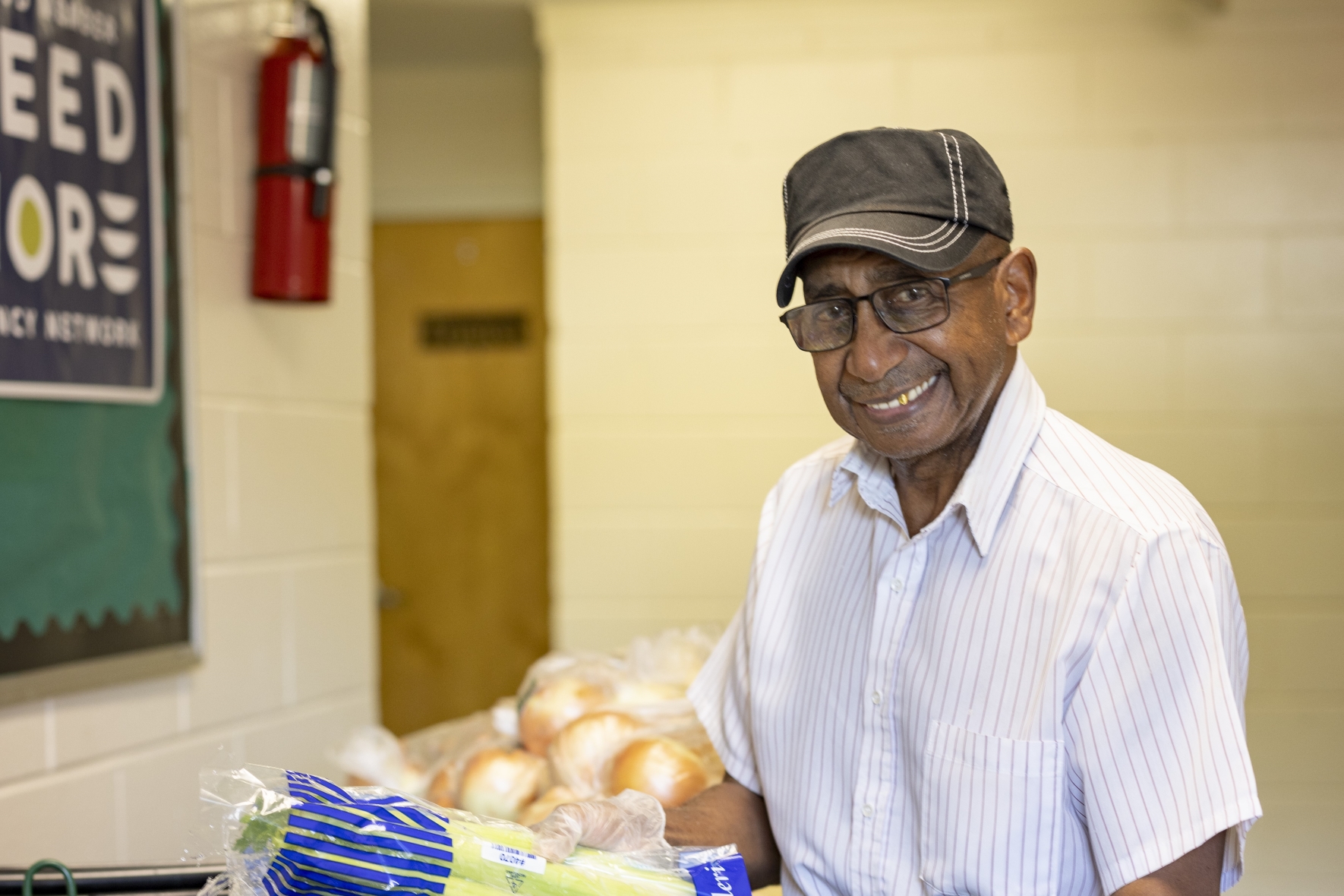 Smiling volunteer at Feed More partner food pantry distribution.