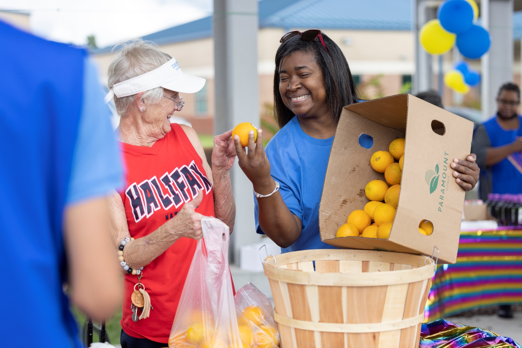 South Boston Elementary School Market organizer Tameka Ferrell hands fruit to a neighbor at the food distribution.