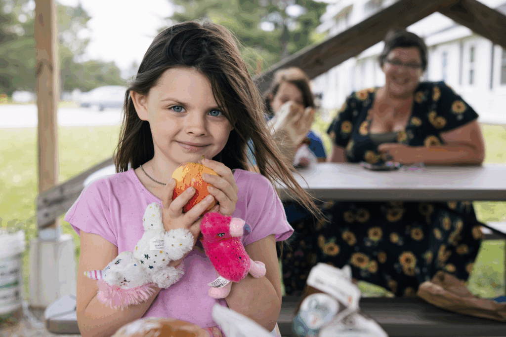 Girl poses for picture at a summer feeding site. In a continued effort to address childhood hunger during the summer, the Virginia Department of Social Services will again partner with the U.S. Department of Agriculture's Food and Nutrition Service to issue Virginia SUN Bucks, a grocery benefit program designed to help eligible school-age children meet their nutritional needs and continue to thrive when school meals are unavailable.
