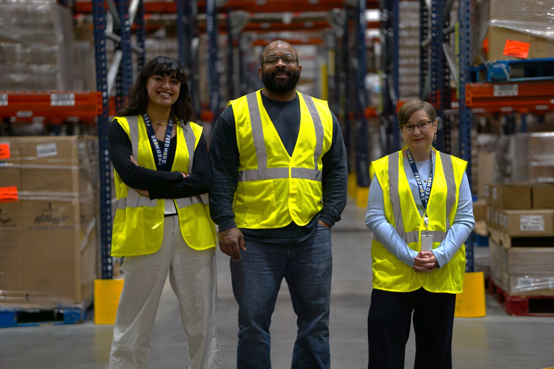 Feed More employees pose for photo in Feed More's Distribution Center. They are: Meals on Wheels Case Manager JanLou Lawson, Inventory Control Manager Tobarrus Hollingsworth, and Senior Manager, Meals on Wheels Case Management and Client Services Lisa Webb.
