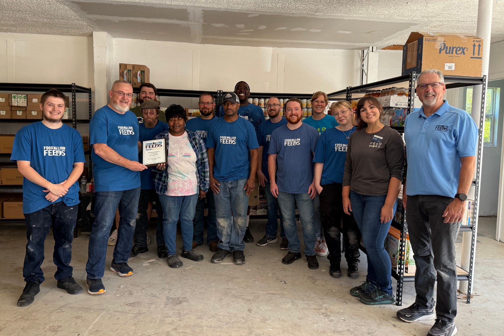 Food Lion Feeds Great Pantry Makeover. Food Lion employees pose for photo at St. Luke Church of God in Christ food pantry, a Feed More distribution partner.