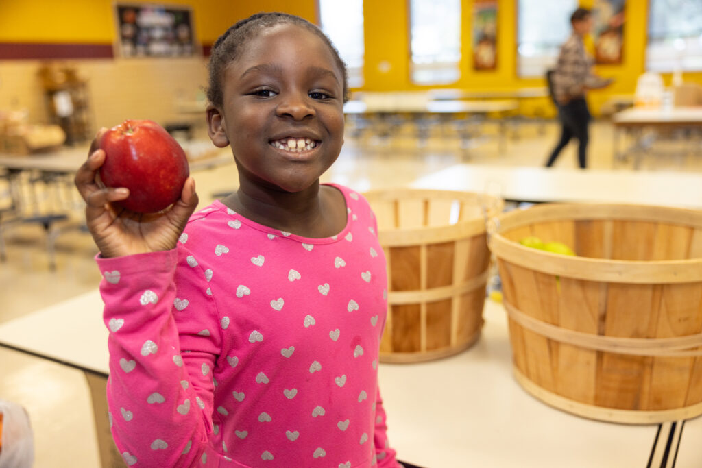 Young girl picks out fresh produce at the school market distribution in Henrico County.